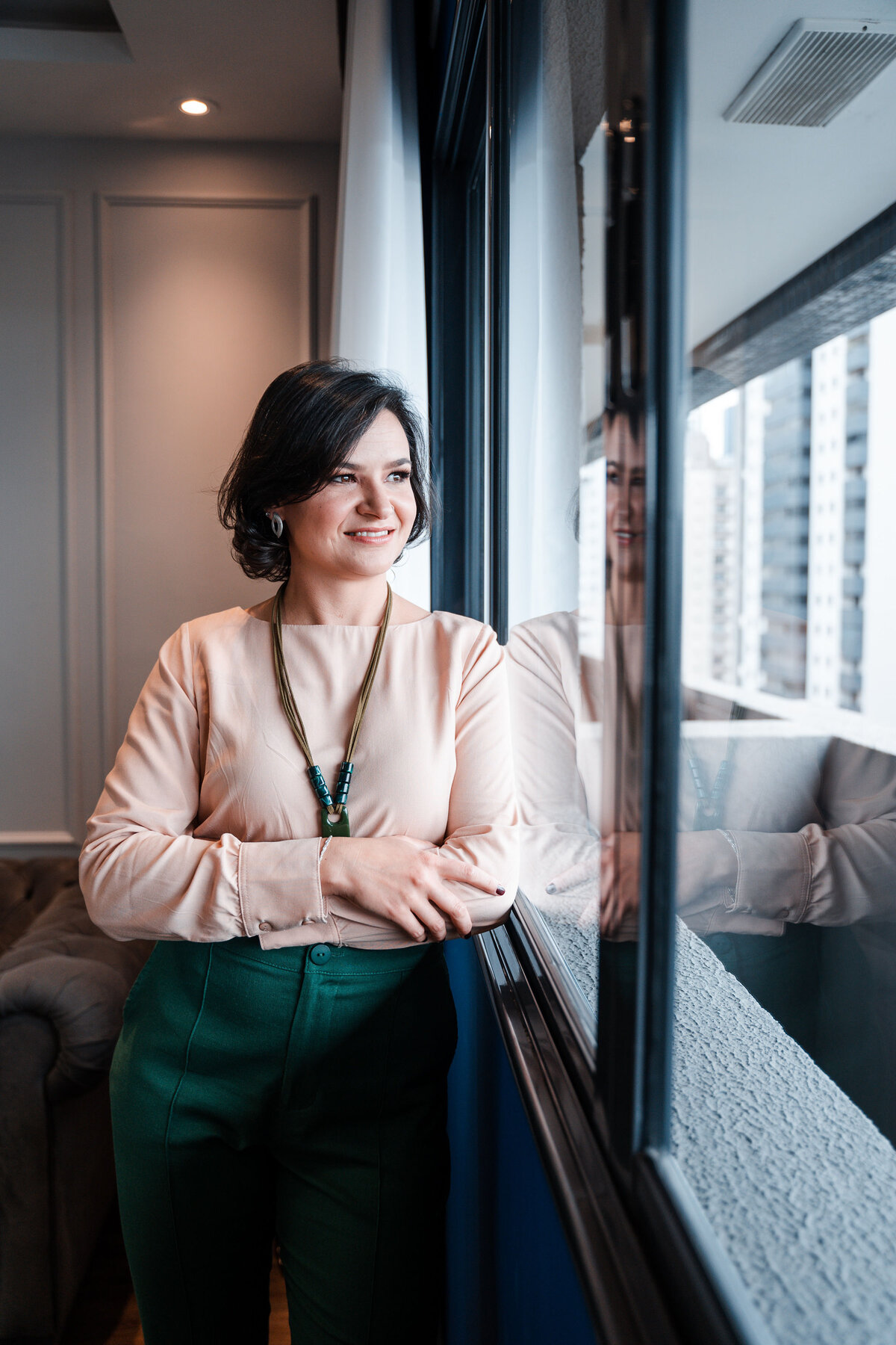 Ana Cristina Schneider no consultório, junto à janela